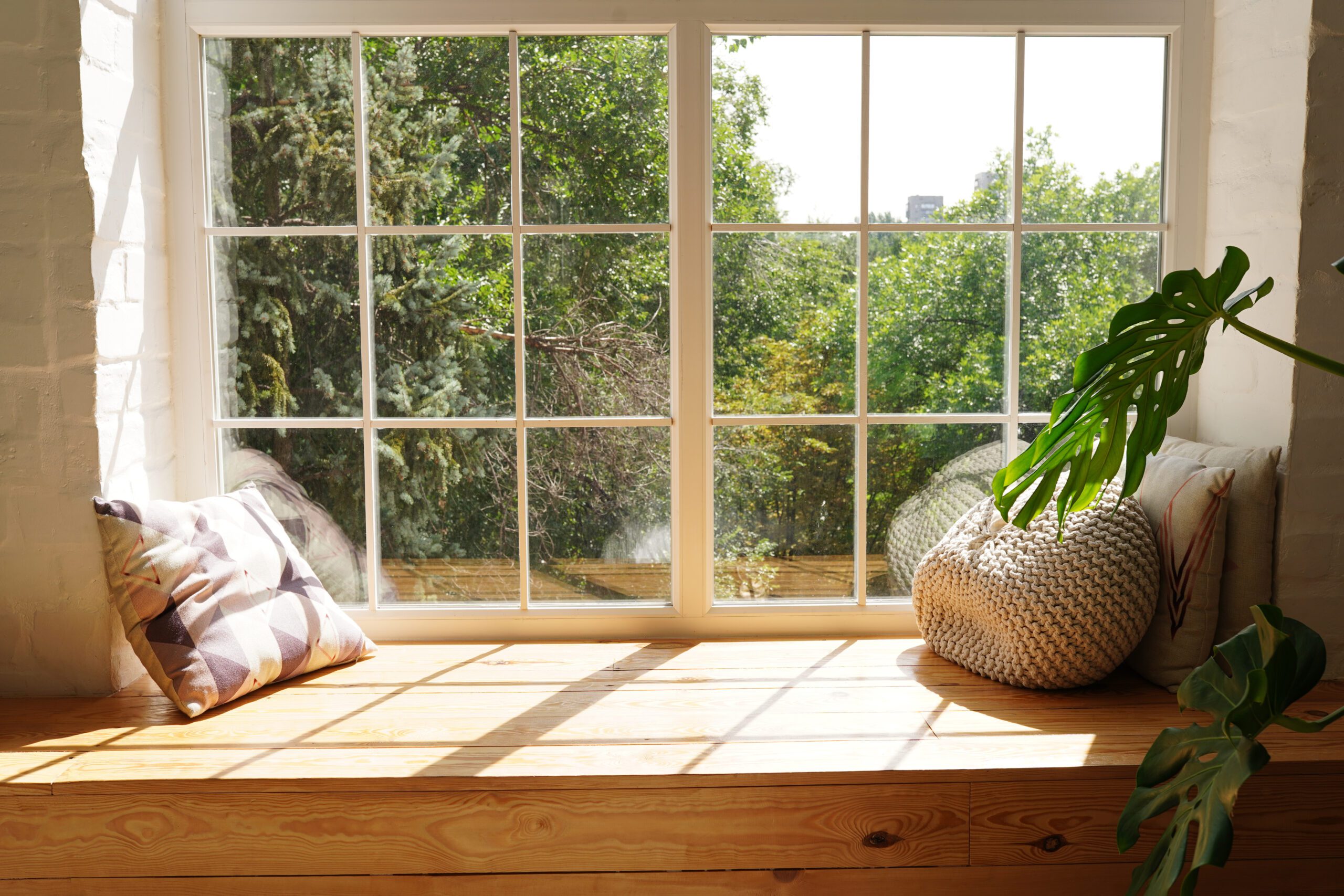 Large glass windows in sitting room with trees outside